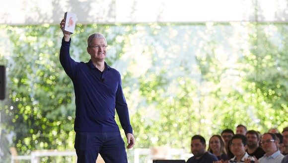 CEO Tim Cook hält das einmilliardste iPhone bei einem Mitarbeitertreffen in Cupertino hoch.